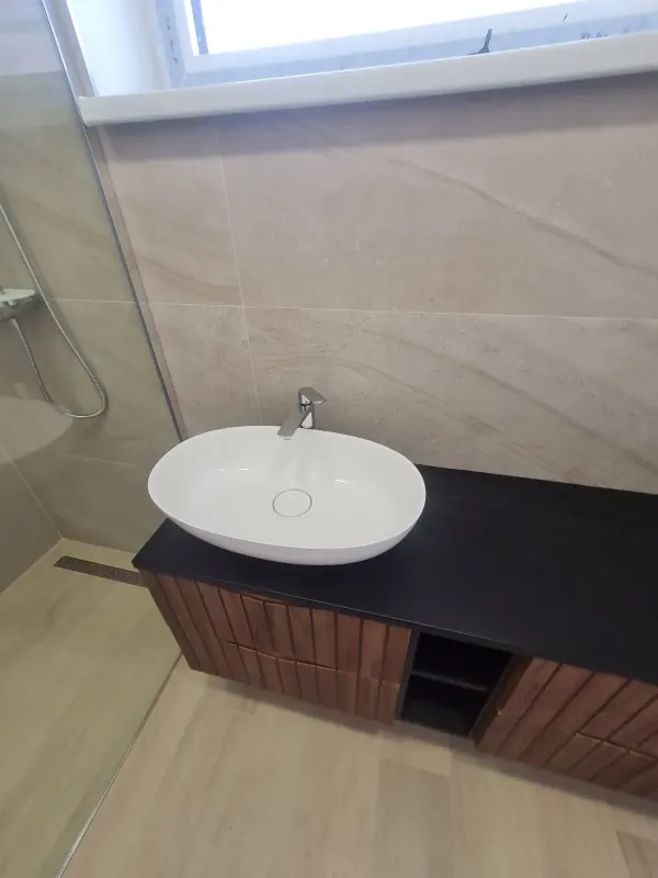 Kúpeľňa - drevené umývadlo, čierna doska a okrúhle zrkadlo - Bratislava