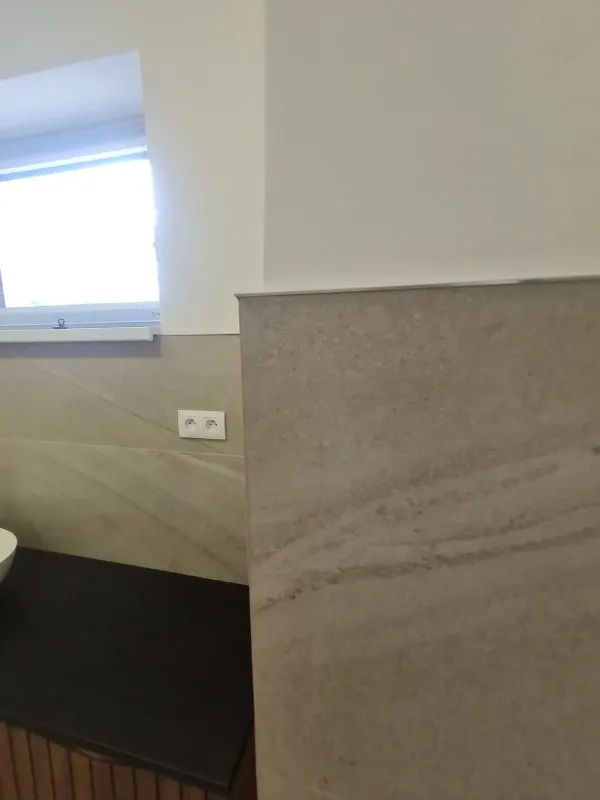 Detail kúpeľne - kameňový obklad a čierna doska pri okne - Bratislava